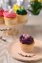 Photo of Tasty Easter cupcakes on wooden table, selective focus