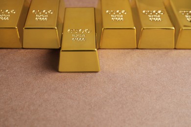 Many shiny gold bars on brown background