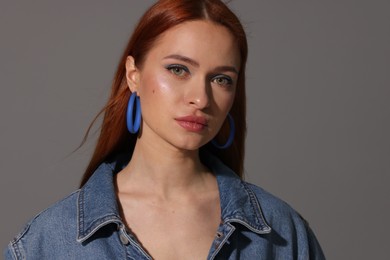 Photo of Beautiful young woman in denim jacket on gray background