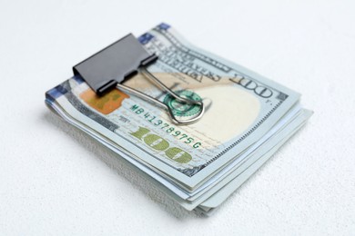 Photo of Many dollar banknotes with paper clip on white table, closeup