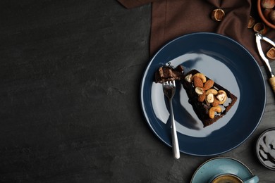 Piece of tasty homemade chocolate cake with nuts served on black table, flat lay. Space for text