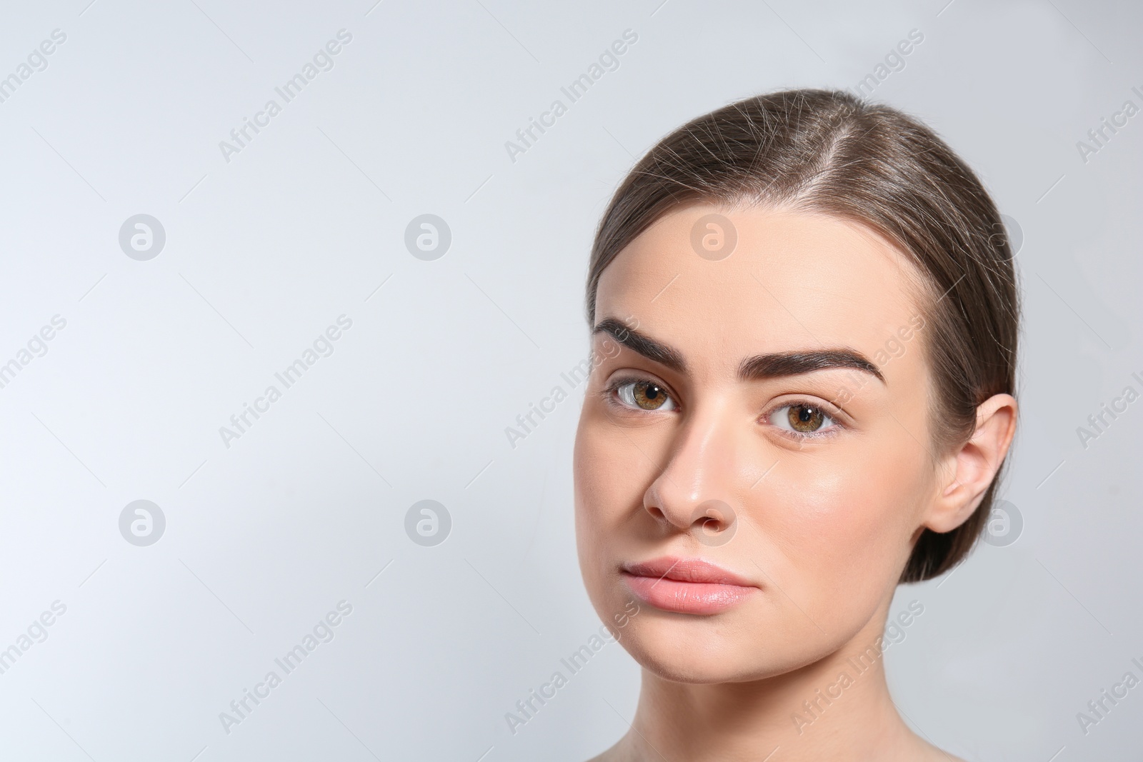 Photo of Beautiful woman with perfect eyebrows on light background