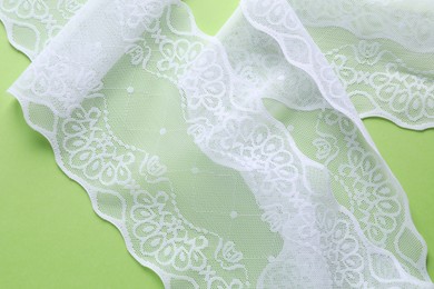 White lace on green background, top view