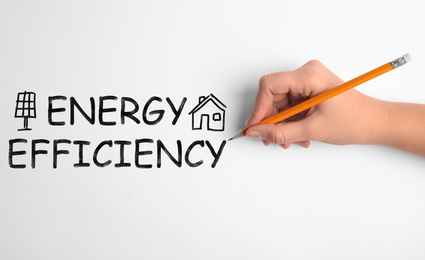 Image of Energy efficiency concept. Woman writing on white background, closeup