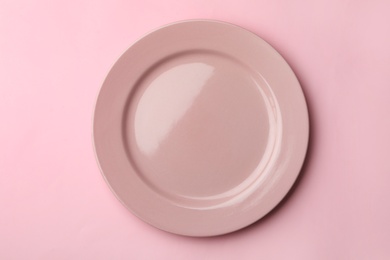 Clean empty plate on color background, top view