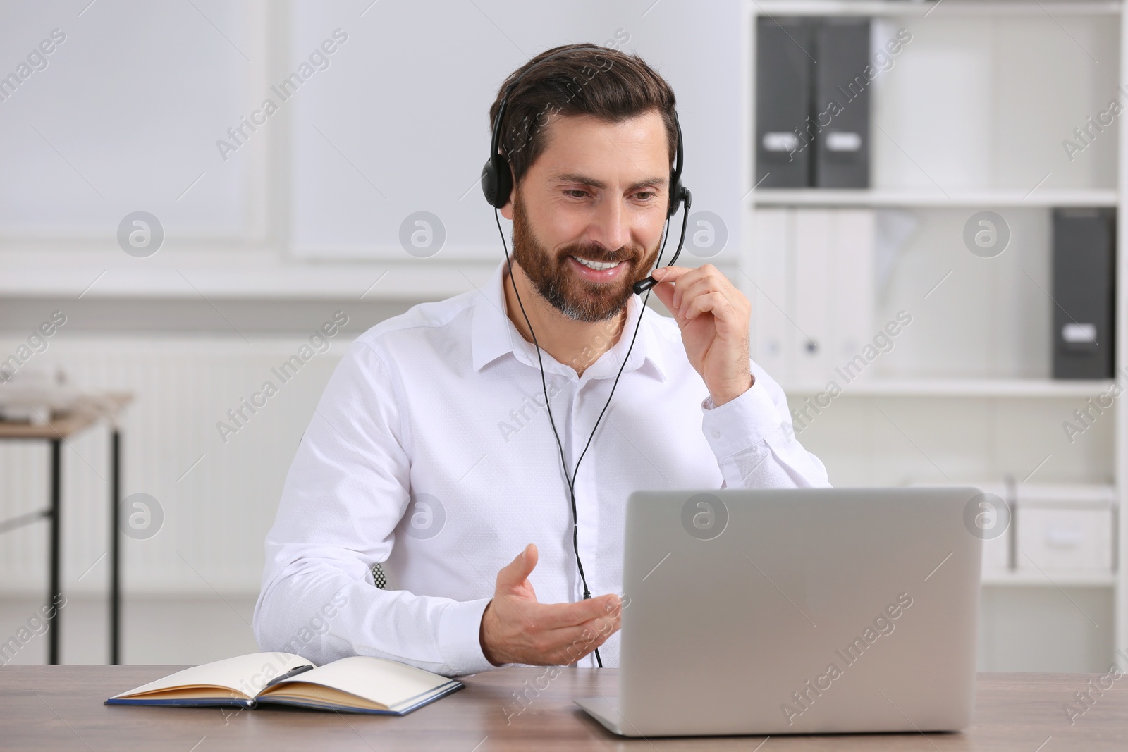 Photo of Hotline operator with headset working in office