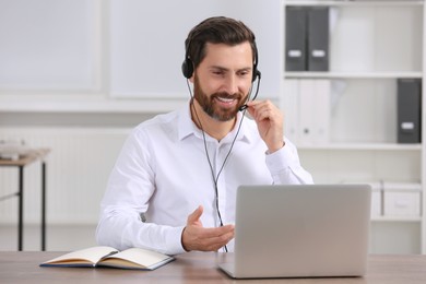 Hotline operator with headset working in office