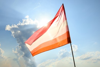 Photo of Bright lesbian flag fluttering against blue sky