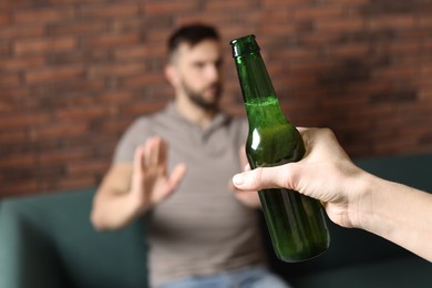 Photo of Man refusing to drink beer indoors, closeup. Alcohol addiction treatment