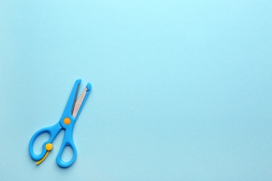 Training scissors on color background, top view. Space for text