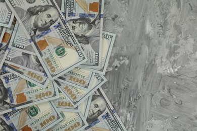 Photo of Money exchange. Dollar banknotes on grey stone background, top view. Space for text