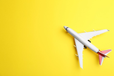 Photo of Toy airplane on yellow background, top view. Space for text