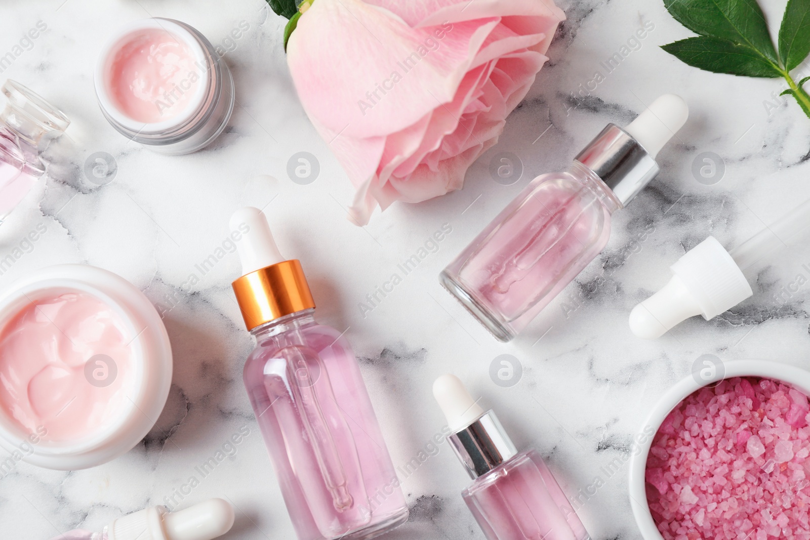 Photo of Flat lay composition with rose essential oil on marble table