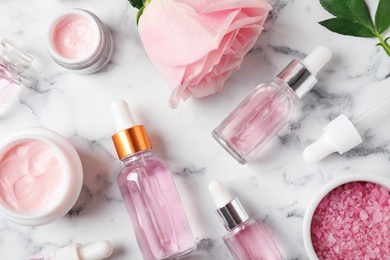 Photo of Flat lay composition with rose essential oil on marble table