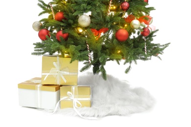 Photo of Beautiful decorated Christmas tree with skirt and gift boxes on white background