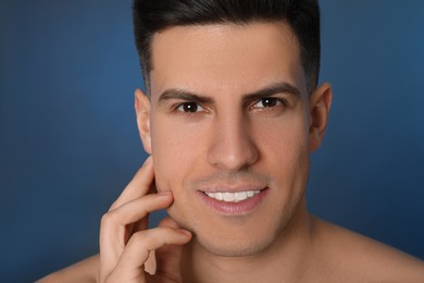 Photo of Handsome man after shaving on blue background, closeup