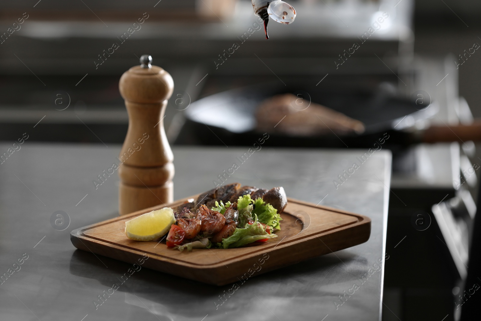 Photo of Adding sauce to tasty meal on table in restaurant kitchen. Cooking food