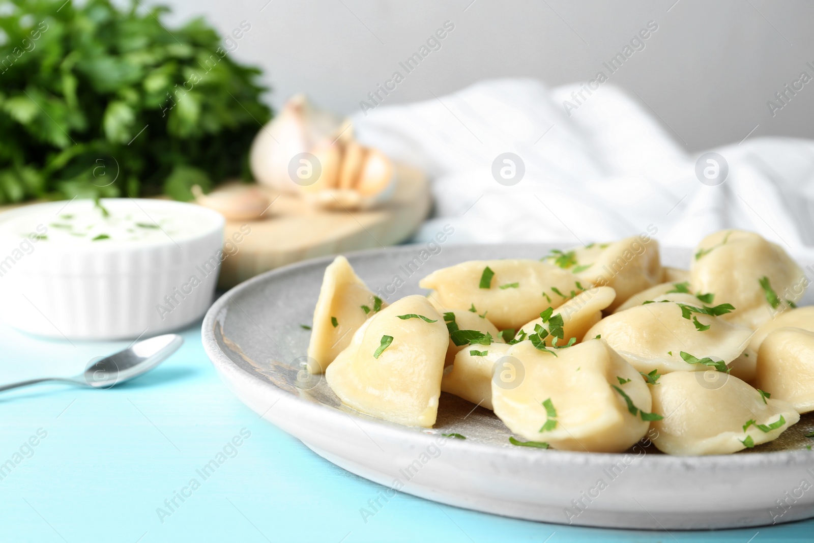 Photo of Delicious cooked dumplings on light blue wooden table