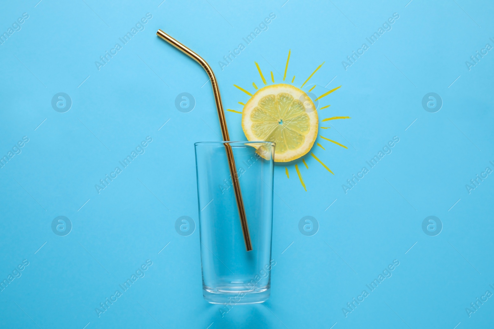 Photo of Composition with citrus slice as sun, straw and glass on color background, top view. Summer cocktail