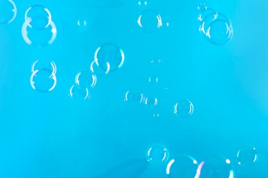 Photo of Beautiful transparent soap bubbles on light blue background