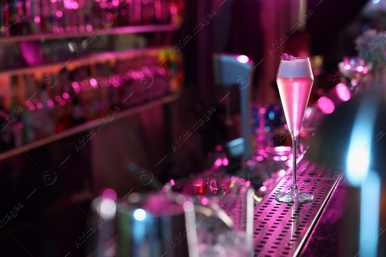 Photo of Fresh alcoholic cocktail on counter in bar. Space for text