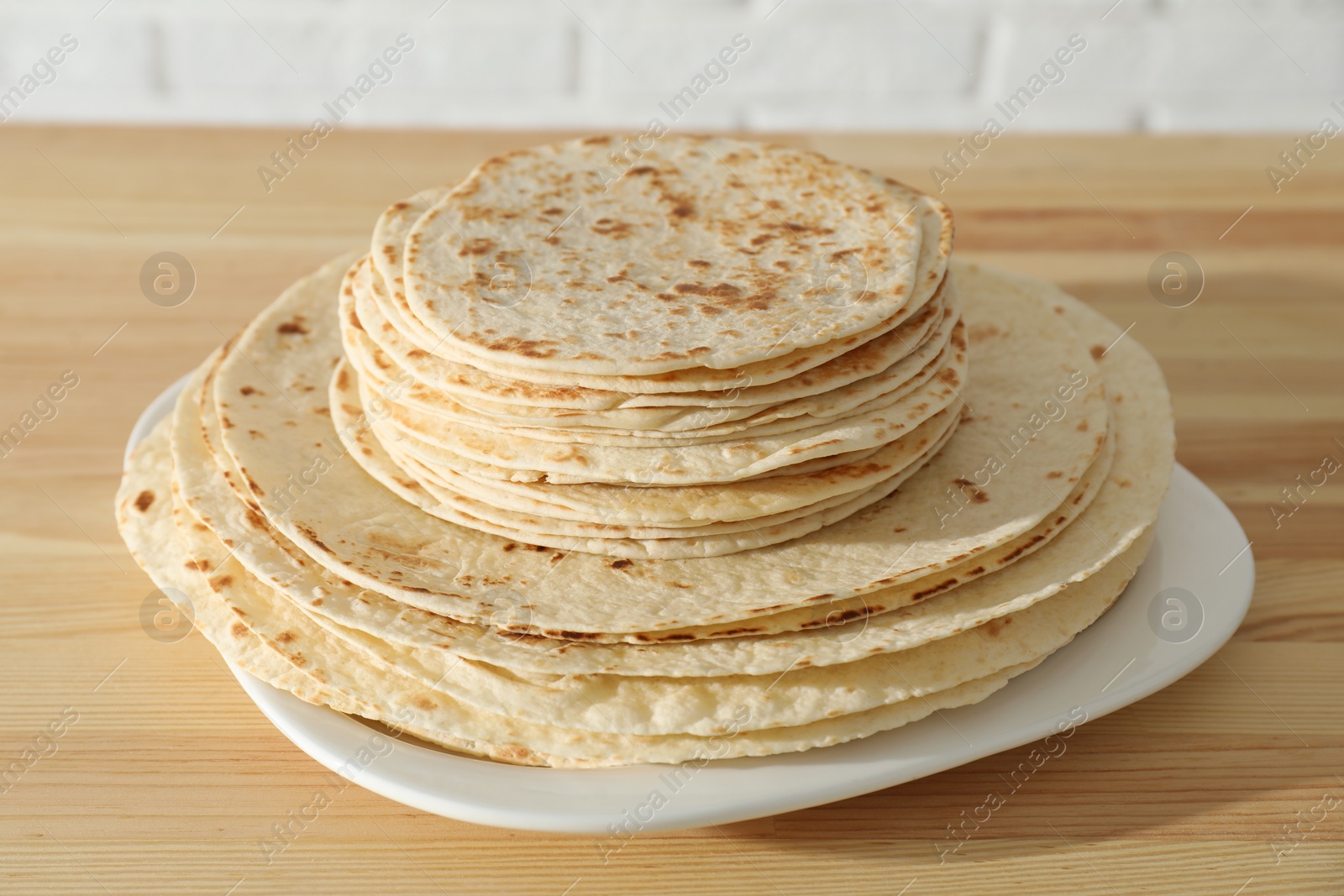 Photo of Many tasty homemade tortillas on wooden table