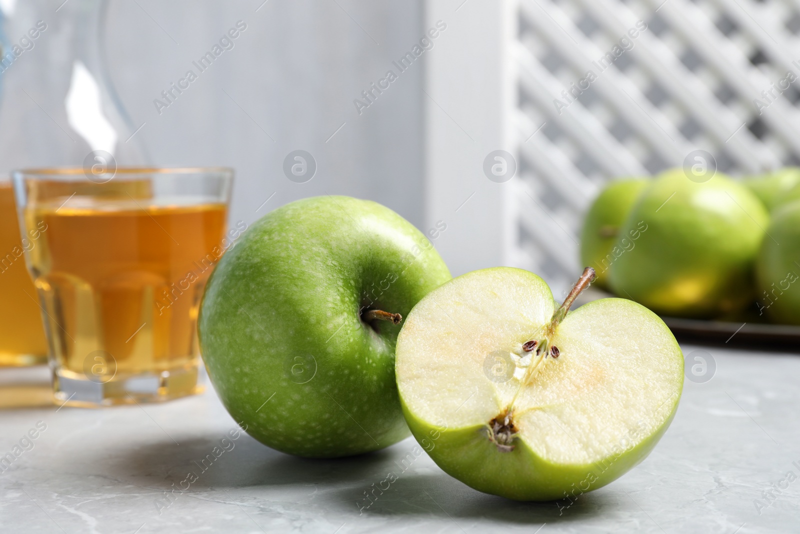 Photo of Cut and whole fresh green apples on grey table, closeup