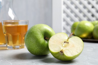 Photo of Cut and whole fresh green apples on grey table, closeup