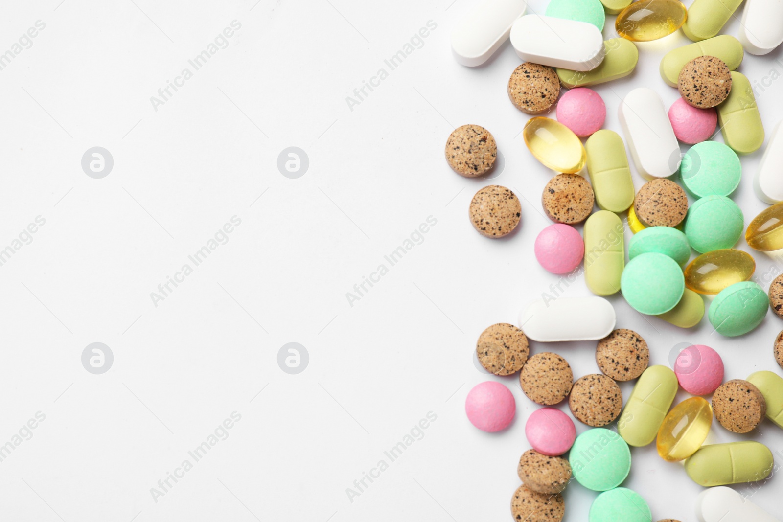 Photo of Different vitamin pills on white background, flat lay. Space for text