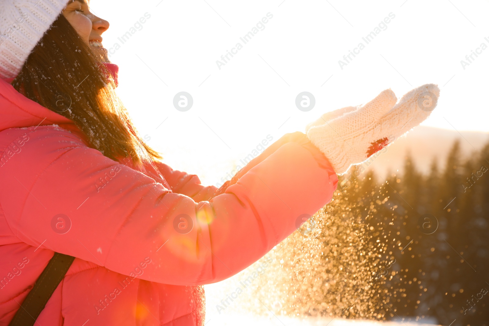 Photo of Young woman having fun outdoors on snowy winter day, closeup