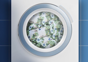 Image of Money laundering. Many euro banknotes in washing machine