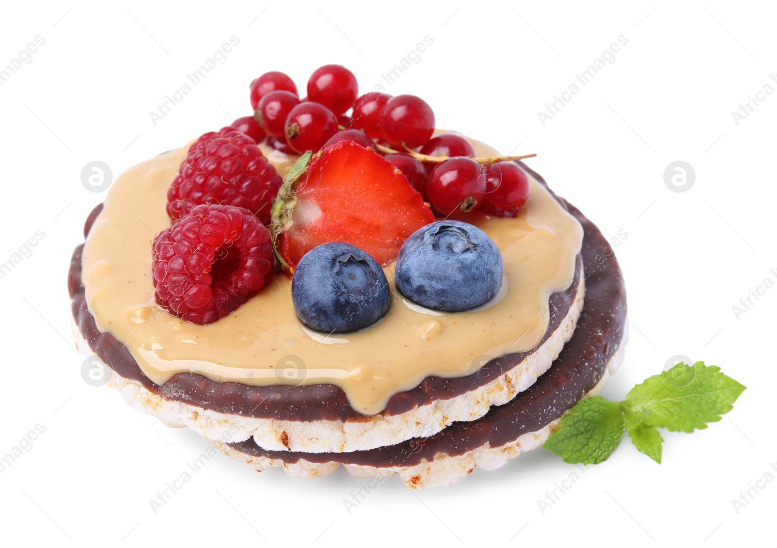Photo of Crunchy rice cakes with peanut butter and sweet berries isolated on white