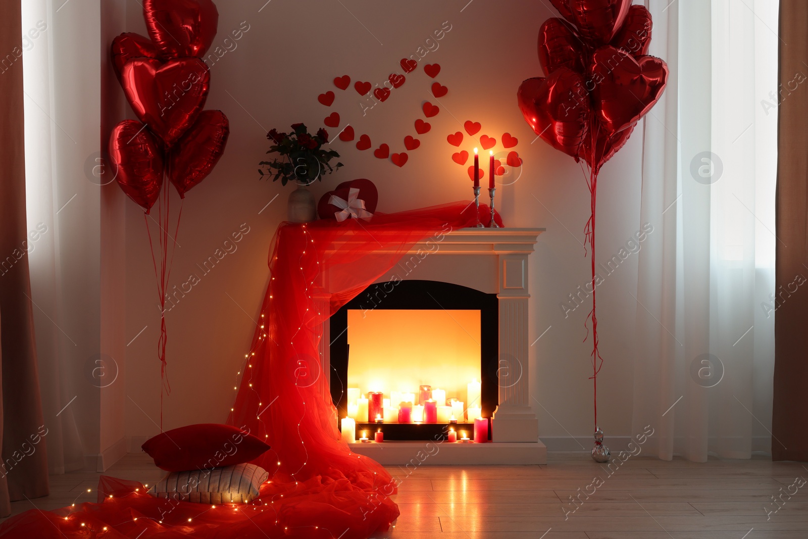 Photo of Stylish room with fireplace and Valentine's day decor. Interior design