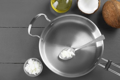 Photo of Flat lay composition with frying pan and organic coconut cooking oil on grey wooden table