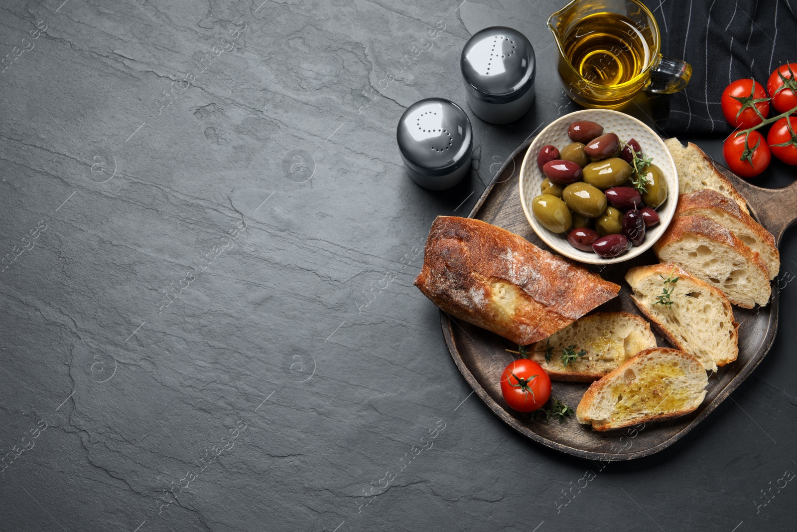 Photo of Tasty bruschettas with oil on grey table, flat lay. Space for text