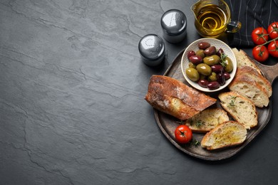 Tasty bruschettas with oil on grey table, flat lay. Space for text