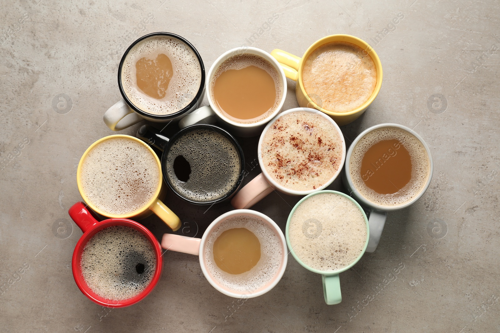 Photo of Many cups with different aromatic coffee on light grey table, flat lay