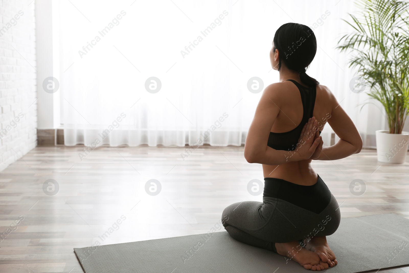 Photo of Young woman practicing seiza asana in yoga studio. Vajrasana pose