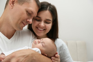 Photo of Happy family with their cute sleeping baby on grey background