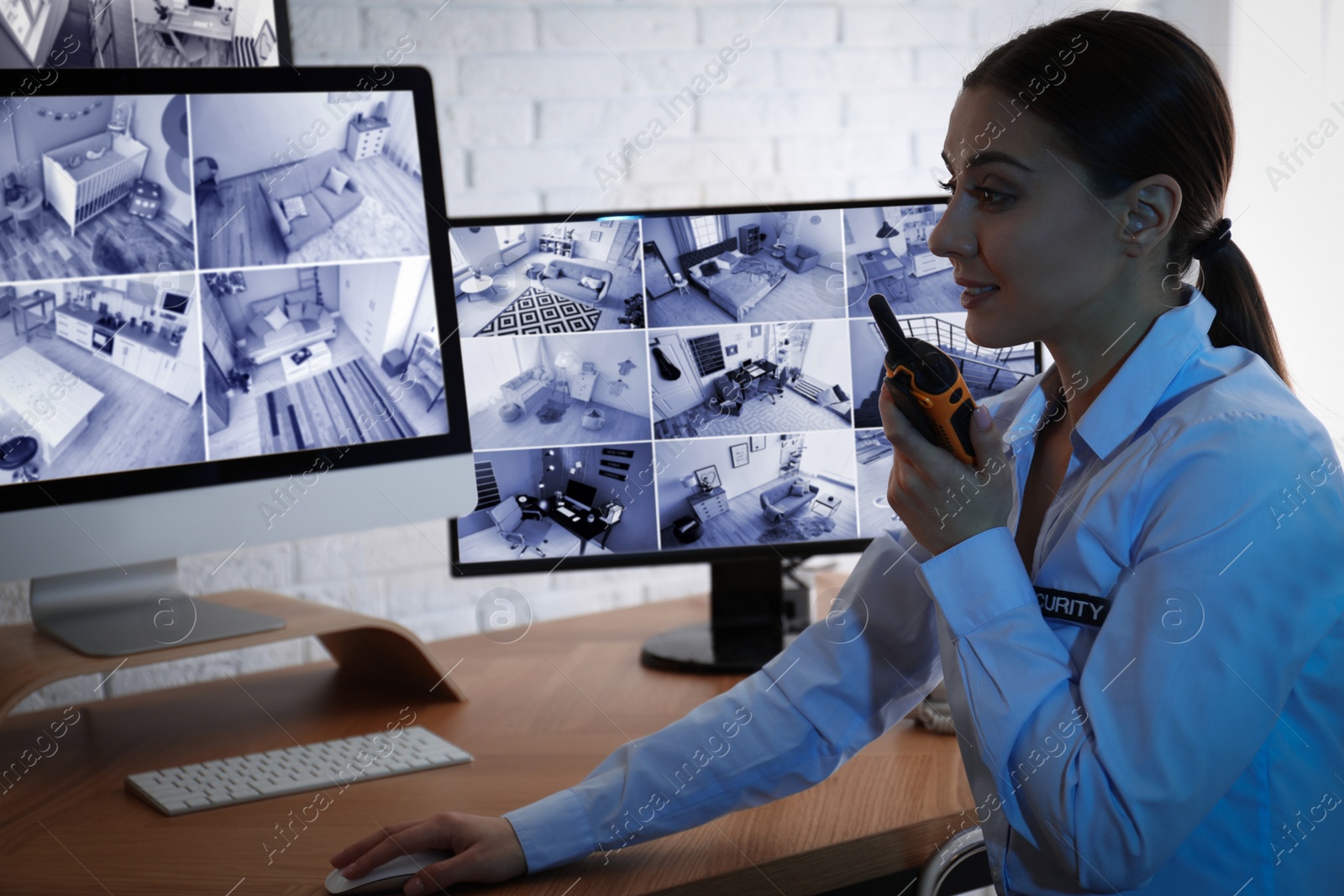 Photo of Female security guard with portable transmitter at workplace