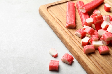 Photo of Cut crab sticks on light table, closeup. Space for text