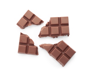 Photo of Delicious milk chocolate pieces on white background, top view