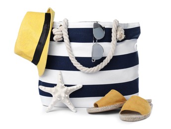 Stylish bag with beach accessories isolated on white