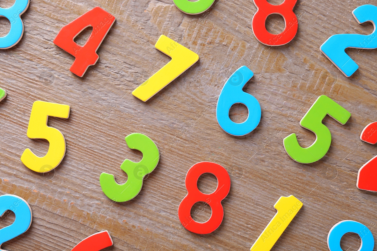 Photo of Colorful numbers on wooden table, flat lay