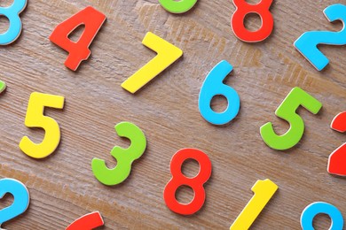 Photo of Colorful numbers on wooden table, flat lay