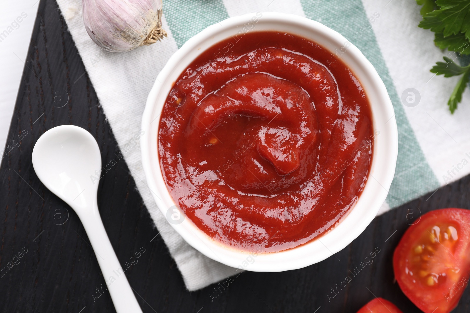 Photo of Organic ketchup in bowl on table, flat lay. Tomato sauce