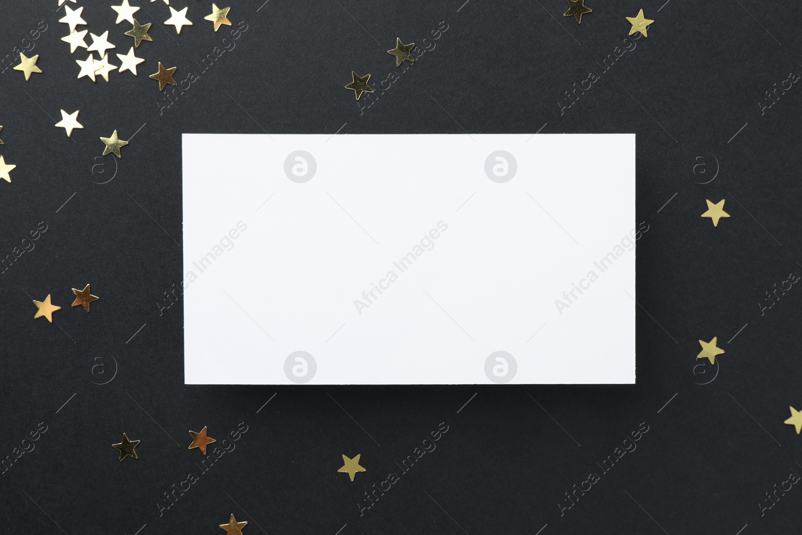 Photo of Blank business card and confetti on black background, top view. Mockup for design