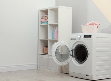 Photo of Modern washing machine in laundry room interior. Space for design