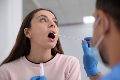 Doctor taking sample for DNA test from woman in clinic