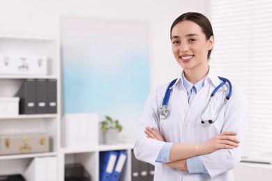 Medical consultant with stethoscope in clinic, space for text